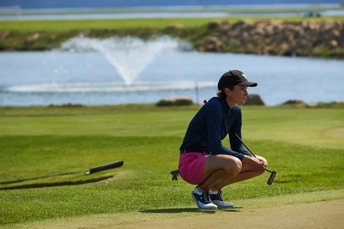 Aleksandra Chekalina reading the line of a putt beside the green