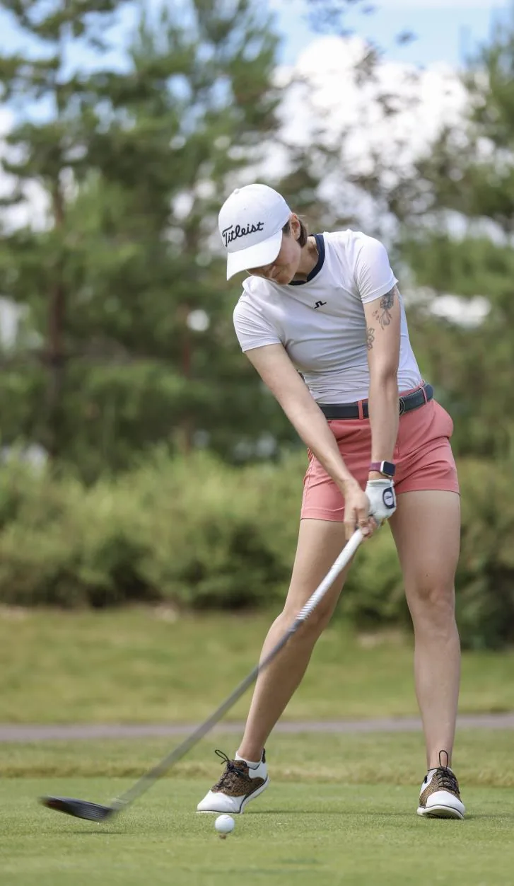 Aleksandra Chekalina addressing the ball with a driver on the tee