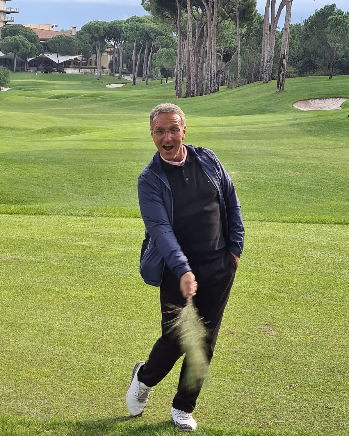 Mahmut Baran completing a golf shot as the divot rises from the fairway
