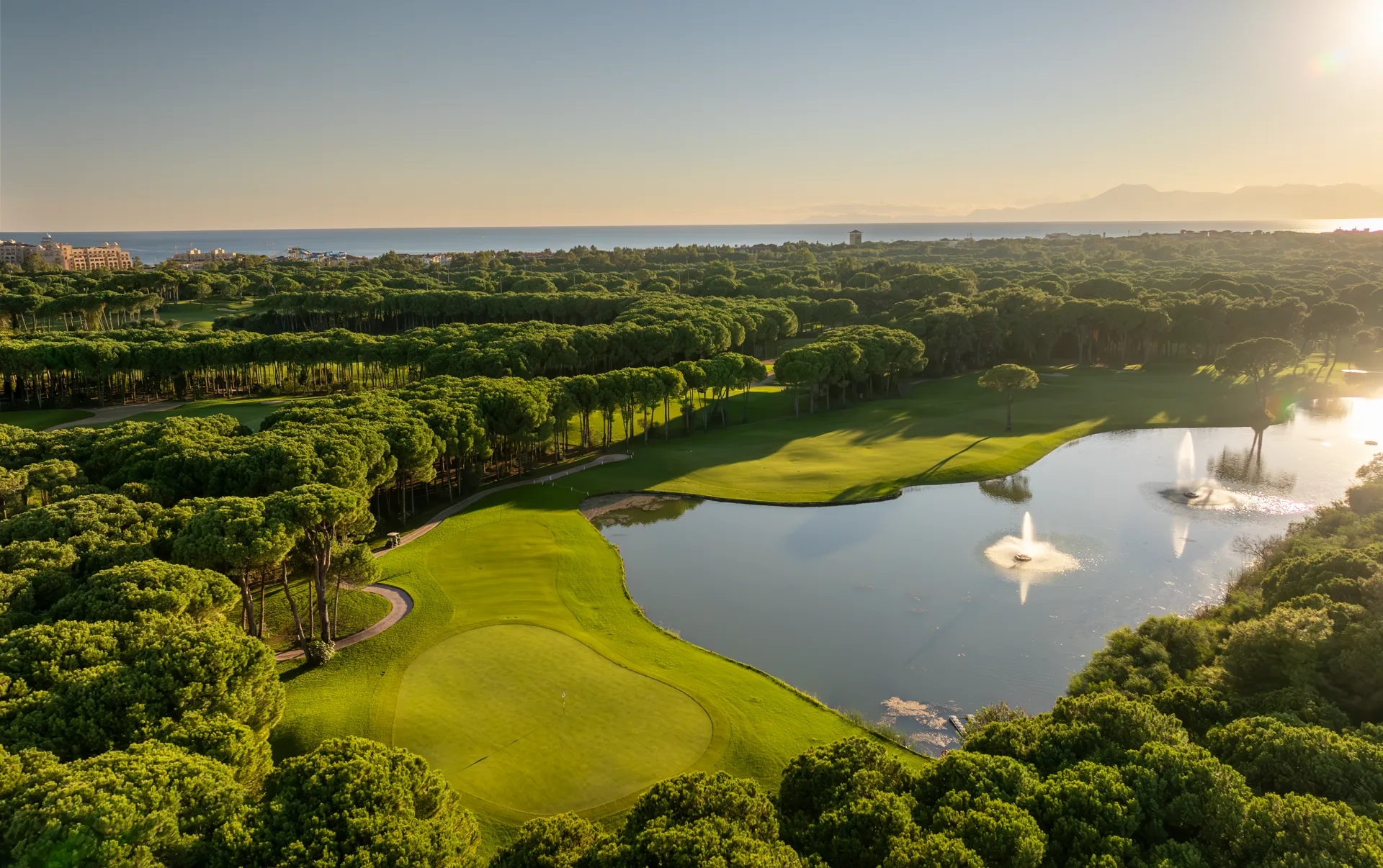 Aerial view across Montgomerie Maxx Royal towards the Mediterranean at golden hour